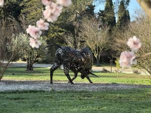 a statue of a dog running in a park at Mas d'Auseu in Cavaillon