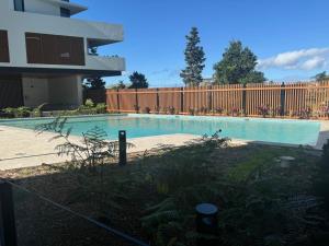 a swimming pool in a yard next to a fence at Sunshine Coast Paradise in Maroochydore