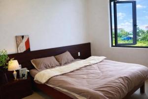 a large bed in a bedroom with a window at Pavillon D'Hue Homestay in Hue