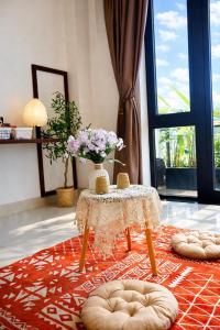 a room with a table with a vase of flowers on it at Pavillon D'Hue Homestay in Hue
