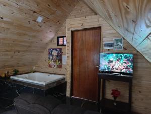 a bathroom with a tub and a tv in a room at Posada Turística Alpinas Kamba in Paraguarí