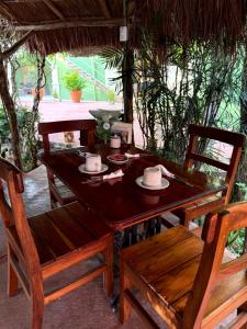 a wooden table with two chairs and a table with cups at Casa Xu´unan in Valladolid