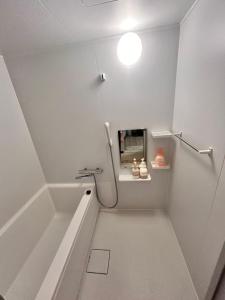 a white bathroom with a tub and a sink at 梅田 天王寺へ電車一本 福宿平野 in Osaka