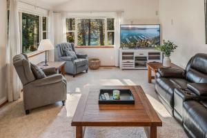 a living room with a couch and a tv at Private Riverfront Estate with Kayaks & Views in Post Falls +51 photos