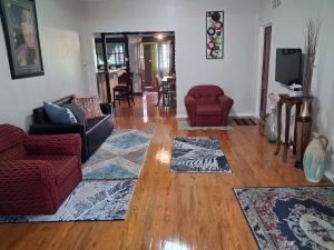 a living room with couches and rugs on a wooden floor at Apianas BnB in Suva