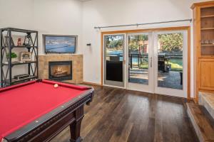 a room with a pool table and a fireplace at Private Riverfront Estate with Kayaks & Views in Post Falls