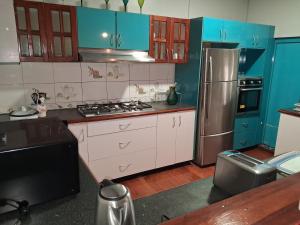 a kitchen with blue cabinets and a stainless steel refrigerator at Apianas BnB in Suva