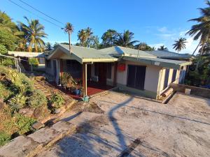 a small house with palm trees in the background at Apianas BnB in Suva