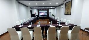 a conference room with a long table and white chairs at Hotel Butik Sawunggaling in Bandung