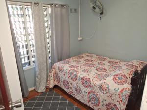 a bedroom with a bed with a floral comforter at Apianas BnB in Suva