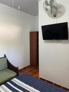 a bedroom with a bed and a flat screen tv at La Casa de Luzma in Pueblo Bello
