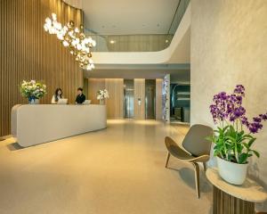 a lobby with two people at a reception desk at ROYS Hotel Bangkok in Bangkok