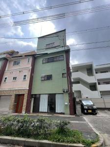 a building with a car parked in front of it at 梅田 天王寺へ電車一本 福宿平野 in Osaka