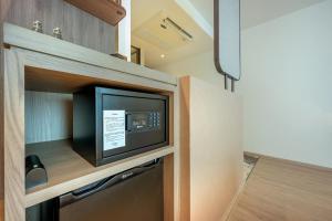 a kitchen with a microwave oven in a cabinet at ROYS Hotel Bangkok in Bangkok