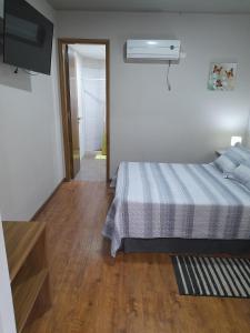 a bedroom with a bed and a television and a hallway at Loft Centro Cívico in San Juan