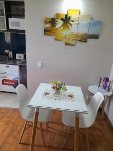 a white table with chairs and a vase of flowers on it at Loft Centro Cívico in San Juan