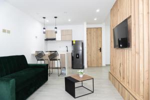 a living room with a green couch and a kitchen at Hotel STATION 23 in Ibagué