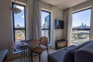 a living room with a couch and a table with chairs at Edificio ON in Blumenau