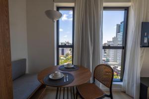 a room with a table and chairs and a large window at Edificio ON in Blumenau