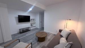 a living room with a couch and a table at Private Creekstone Basement Suite with Kitchen in Calgary