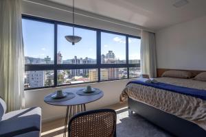 a bedroom with a bed and a large window at Edificio ON in Blumenau +242 photos