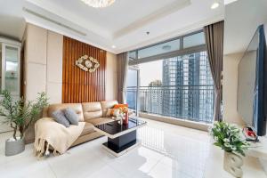 a living room with a couch and a large window at Elysian Suites In Landmark Saigon by VNS in Ho Chi Minh City