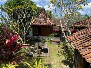 a house with a garden in front of it at Villa Nextdoor Nature Yogyakarta in Bantul