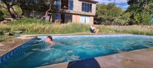 a man in a swimming pool next to a house at ecolodge San miguel in Tupiza