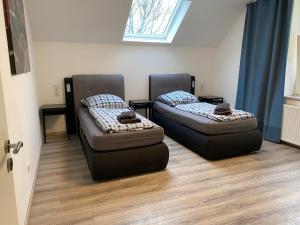 two beds in a room with a window at Ferienwohnung Modern 2 Rooms 4 Beds in Essen +1 photo