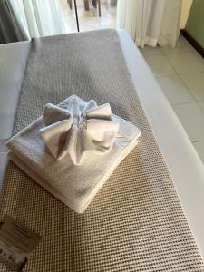 a white napkin with a bow on a bed at Ivan Pousada e Churrascaria Bode na Brasa in Feira de Santana
