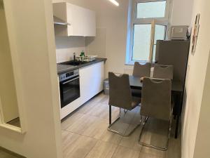 a kitchen with a table and some chairs in it at Ferienwohnung Modern 2 Rooms 4 Beds in Essen