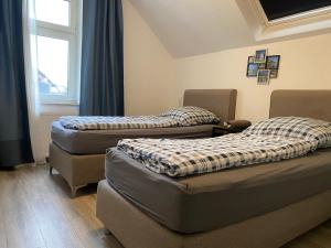 two beds sitting in a room with a window at Ferienwohnung Modern 2 Rooms 4 Beds in Essen