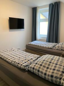two beds in a room with a tv on the wall at Ferienwohnung Modern 2 Rooms 4 Beds in Essen