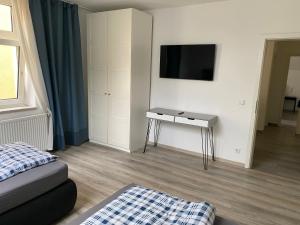 a bedroom with a table and a tv on a wall at Ferienwohnung Modern 2 Rooms 4 Beds in Essen