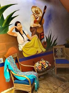 a room with a mural of a woman playing a guitar at Hotel Los Faroles, Villa del Carbón in Villa del Carbón