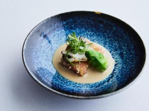 a blue plate with a piece of food on it at SETOUCHI RETREAT AONAGI by Onko Chishin in Matsuyama