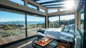 a bedroom with a bed and a view of the mountains at Tāima PurePod in Cromwell
