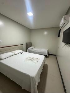 a hotel room with two beds and a tv at Ivan Pousada e Churrascaria Bode na Brasa in Feira de Santana