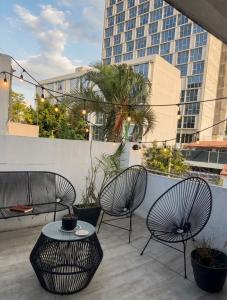 two chairs and a table on a balcony with a building at suite doble ejecutiva providencia in Guadalajara