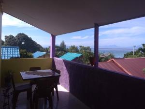a table and chairs on a balcony with a view of the ocean at pulau weh sabang marifi in Paya