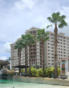 a hotel with palm trees in front of a building at Boulevard suíte hotel suíte 1220 in Caldas Novas