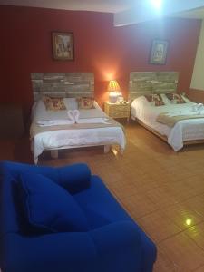 a living room with two beds and a couch at Hotel Los Faroles, Villa del Carbón in Villa del Carbón
