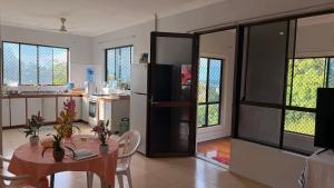 a kitchen with a table and a kitchen with a refrigerator at JNSi Appartments in Honiara
