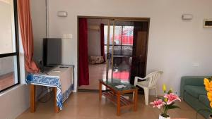 a living room with a couch and a television at JNSi Appartments in Honiara