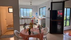 a kitchen with a table and chairs and a kitchen with a refrigerator at JNSi Appartments in Honiara +5 photos
