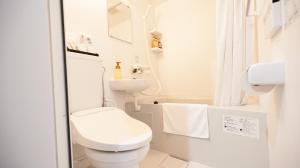 a white bathroom with a toilet and a sink at Rita Hotel Namba in Osaka +60 photos