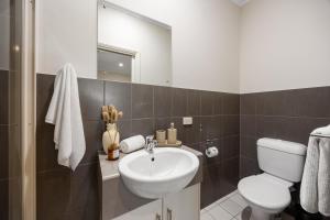 a bathroom with a sink and a toilet and a mirror at Gone Coastal - Family Beachside Breeze in Grange +18 photos