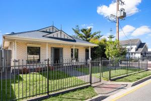 a house with a fence in front of it at Gone Coastal - Family Beachside Breeze in Grange