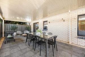 a patio with a table and chairs on it at Gone Coastal - Family Beachside Breeze in Grange