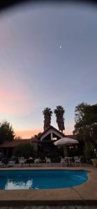 a resort with a pool and a building with palm trees at Bed&Breakfast in Maipo